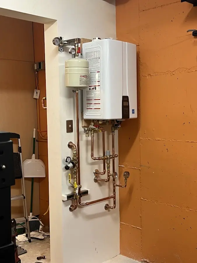 Plumbing technician inspecting water heater connections in Upper Gwynedd